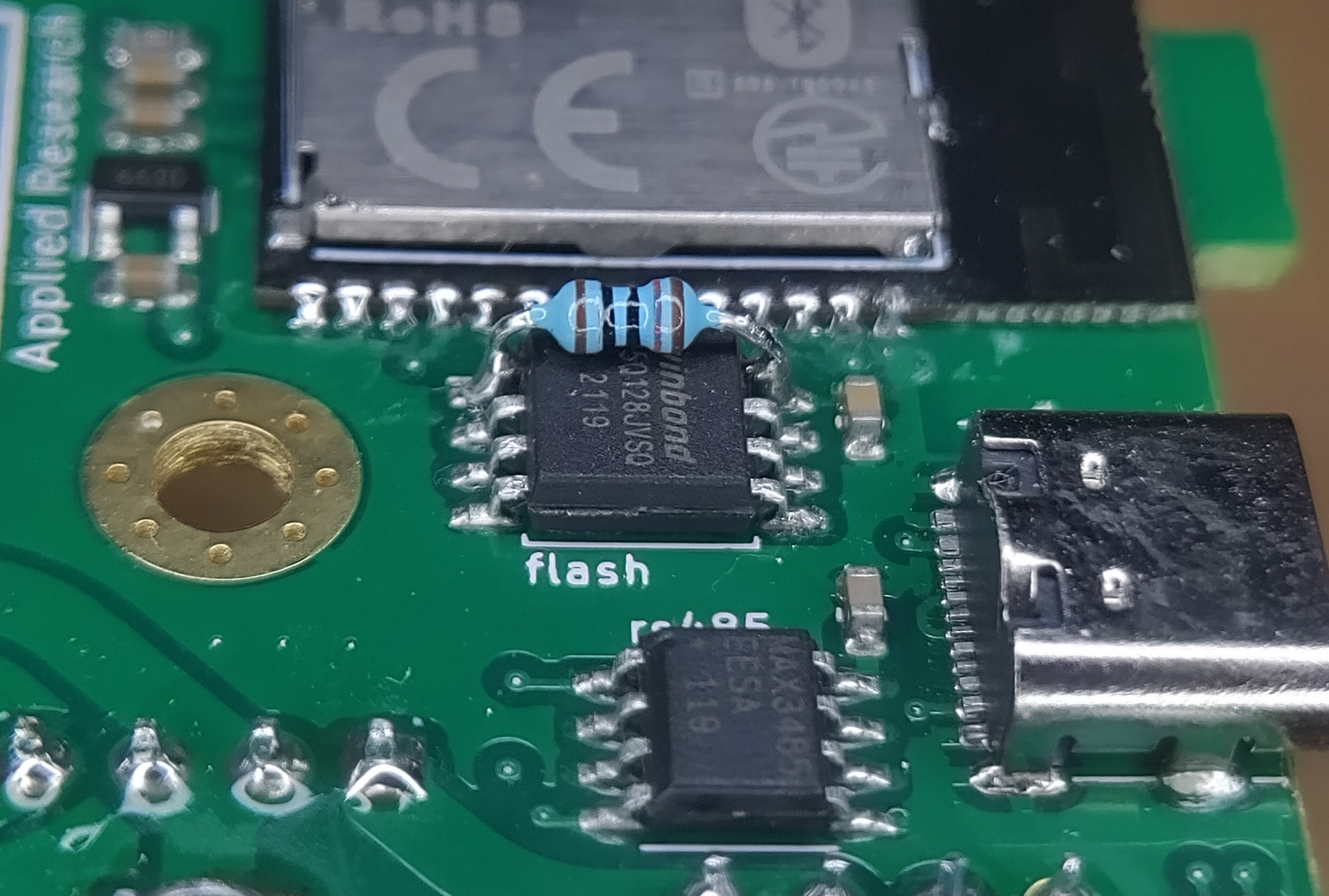 A close-up of the Powerbus Mini PCB, showing a through-hole resistor bodged on top of the memory chip